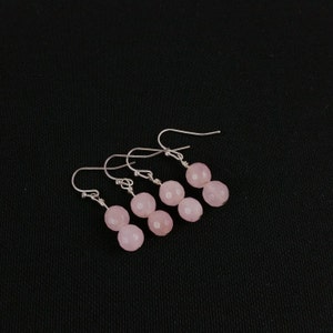 May include: Three pairs of silver earrings with pink gemstone beads. Each earring has two round beads.