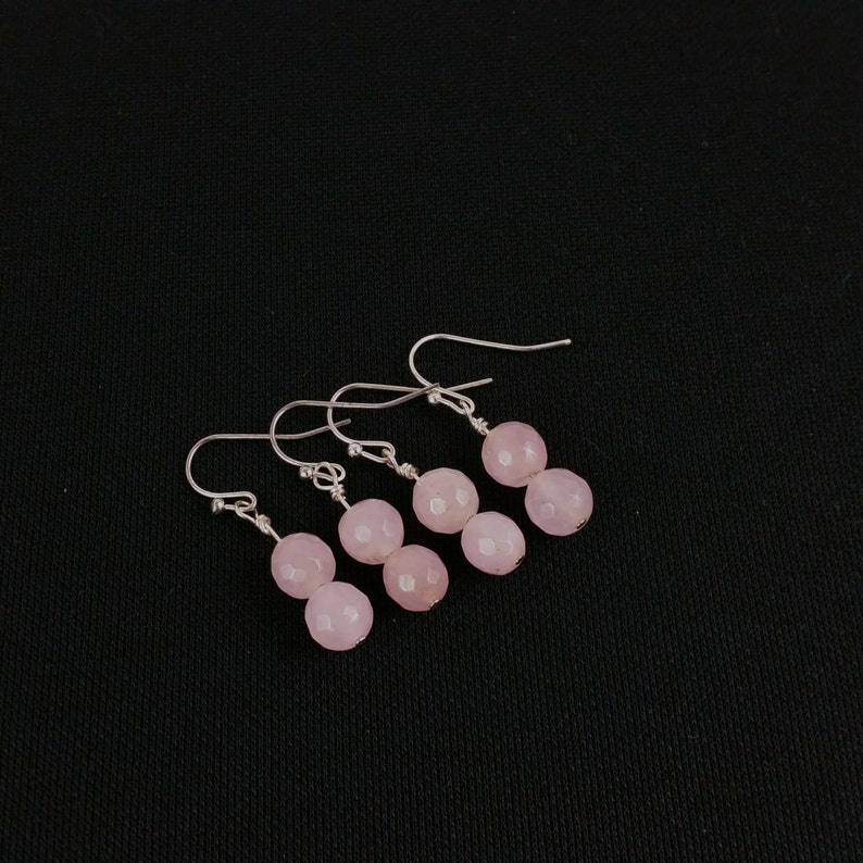 May include: Three pairs of silver earrings with pink gemstone beads. Each earring has two round beads.