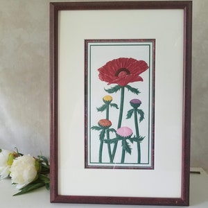 May include: Framed art print featuring a red poppy flower with five smaller flowers in shades of pink, yellow, and orange. The flowers are depicted in a stylized, almost cartoon-like manner, with thick stems and leaves.