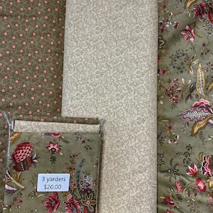 May include: Three fabric panels, each with a different floral pattern. The first panel is a green and pink floral print, the second is a cream and gray floral print, and the third is a green and brown floral print. The panels are labeled "3 yarders $20.00".
