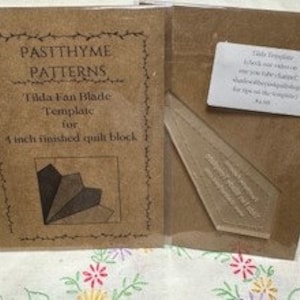 May include: A brown paper template for making a 4 inch quilt block. The template is labeled "Tilda Fan Made Template for a 4 inch finished quilt block." The template is packaged in a brown paper envelope with a white label that says "Pastthyme Patterns".