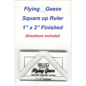 May include: A white plastic "Flying Geese Square up Ruler" with the text "1" x 2" Finished" and "Directions Included". The ruler is designed for quilting and features a clear design for precise measurements. The ruler measures 1 inch by 2 inches.