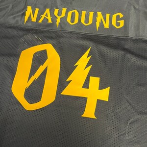 Pu&ograve; includere: Maglia da calcio in mesh nera con il nome "NAYYOUNG" e il numero "04" in giallo con disegni di fulmini.