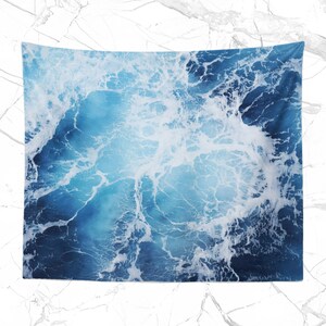 May include: A blue and white tapestry featuring a close-up of ocean waves with white foam.