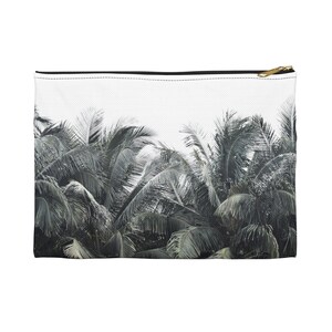 Könnte beinhalten: Eine rechteckige, weiße Reißverschlusstasche mit schwarzem Reißverschluss und goldfarbenem Zug. Die Tasche zeigt ein Graustufenbild von üppigen Palmenwedeln vor weißem Hintergrund und erzeugt eine tropische Ästhetik.
