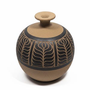 May include: A round, tan ceramic vase with a black leaf pattern encircling the body. The vase has a small, cylindrical neck and a flat, circular top. The design is carved into the surface.