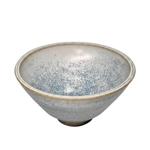 May include: A ceramic bowl with a speckled blue and gray glaze. The bowl has a wide, angled shape with a slightly raised base and a light brown rim. The interior has a textured appearance.