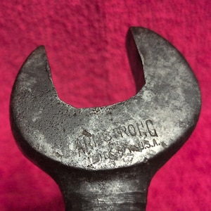 May include: A dark grey metal open-ended spanner featuring a weathered, textured surface. The head of the tool is clearly stamped with the text ARMSTRONG and U.S.A. in capital letters, indicating its origin and manufacturer brand name.