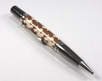 May include: A silver and brown pen with a geometric pattern on the barrel. The pen has a black metal tip and a silver clip.