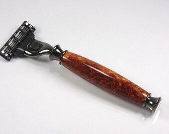 May include: A safety razor with a black and silver head and a brown wooden handle with a marbled pattern.