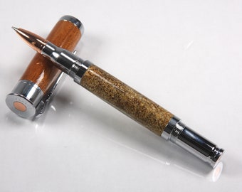 May include: A brown and silver pen with a wooden barrel and a metal nib. The pen is made from a repurposed bullet casing.