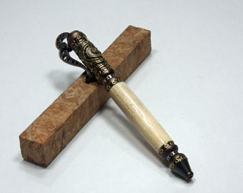 May include: A white and brown pen with intricate gold and copper metalwork details. The pen has a unique design with a decorative loop at the top.