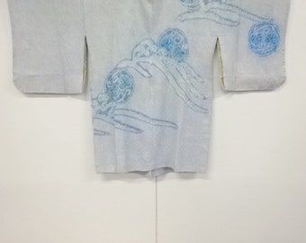May include: A light blue kimono with a textured weave. The kimono features a delicate pattern of stylized blue floral designs. The sleeves are wide and the garment is displayed against a white background.