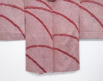 May include: A pink and red Japanese kimono with a curved line pattern. The kimono is made of a textured fabric.
