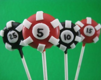 Puede incluir: Cuatro cake pops diseñados como fichas de póquer en palitos. Los cake pops son rojos y negros con detalles blancos y los números 5, 10, 15 y 25. El fondo es verde liso.