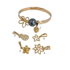May include: Gold bracelet with a black pearl and five charms: a pineapple, a flower, a pine cone, and two more flowers. The charms can be swapped out.