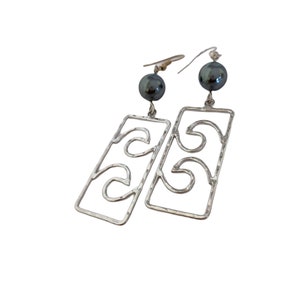 May include: Silver earrings with a geometric design and black gemstone accents.