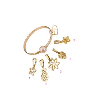 May include: A set of ten gold-toned charms, including a pineapple, a flower, a leaf, and a star. The charms are designed to be used with a bracelet or necklace. The charms are numbered 1 through 5.
