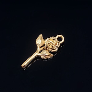 May include: A gold-coloured rose charm with a loop for attaching to a necklace or bracelet.
