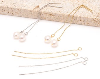May include: Elegant dangle earrings featuring lustrous white pearls. The earrings are available in both silver and gold tones, with delicate chains and post-style closures. The pearls are round and have a smooth, glossy finish, adding a touch of sophistication.
