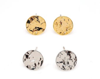 May include: Four stud earrings. Two are gold-coloured with a hammered texture, and two are silver-coloured with a similar hammered texture. The earrings are round and have a post for pierced ears. The earrings are displayed on a white background.