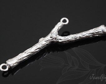 May include: Silver Y-shaped connector with a textured bark-like finish and a single clear rhinestone. The connector has two loops at the ends.