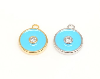 May include: Two round pendants with a light blue enamel finish and a clear rhinestone in the center. One pendant is gold-toned and the other is silver-toned.