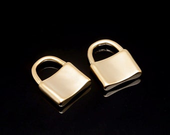 May include: Two gold-coloured padlock charms with a smooth, shiny finish. The padlocks are small and have a simple design.