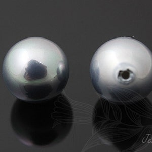 May include: Two round, smooth, gray pearls with a slight iridescent sheen. One pearl has a small hole drilled through it.