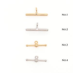 May include: Four metal toggle clasps in gold and silver tones are displayed against a white background. The clasps are labeled No.1 through No.4. Two are straight bar designs, and two have a decorative knot design.