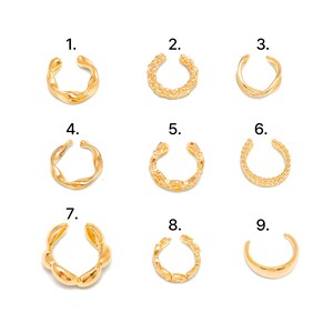 May include: A collection of nine gold-toned ear cuffs arranged in a grid, numbered one through nine. Each cuff features a distinct design, including twisted, braided, beaded, and smooth polished bands, all showcasing an open-ended circular shape.