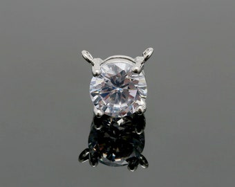 May include: A silver pendant with a clear round cubic zirconia stone.