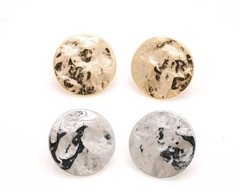 May include: Four round stud earrings. Two are gold-toned with a hammered texture, and two are silver-toned with a similar hammered texture. The earrings are displayed on a white background.