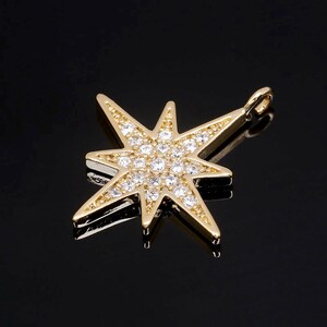 Puede incluir: Encanto de estrella de tono dorado con acentos de cristal transparente. La estrella tiene un diseño puntiagudo y un bucle para sujetarlo a un collar o pulsera.