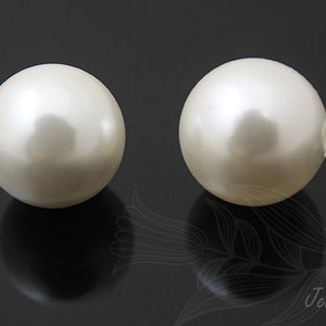 May include: Two white pearl beads, each with a smooth, glossy finish.