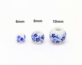 May include: Three white ceramic beads with blue floral patterns. The beads are 6mm, 8mm, and 10mm in diameter. The beads have a hole through the center. The text above the beads indicates their size.
