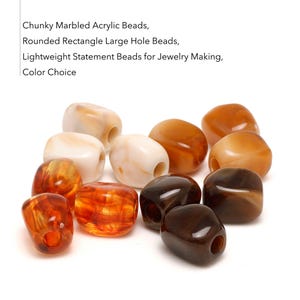 Peut inclure: Perles en acrylique marbré épaisses de forme rectangulaire arrondie avec de grands trous. Les perles présentent diverses couleurs dont le blanc, l'ambre, l'orange et le brun foncé avec des motifs tourbillonnants. Texte : Chunky Marbled Acrylic Beads, Rounded Rectangle Large Hole Beads, Lightweight Statement Beads for Jewelry Making, Color Choice.