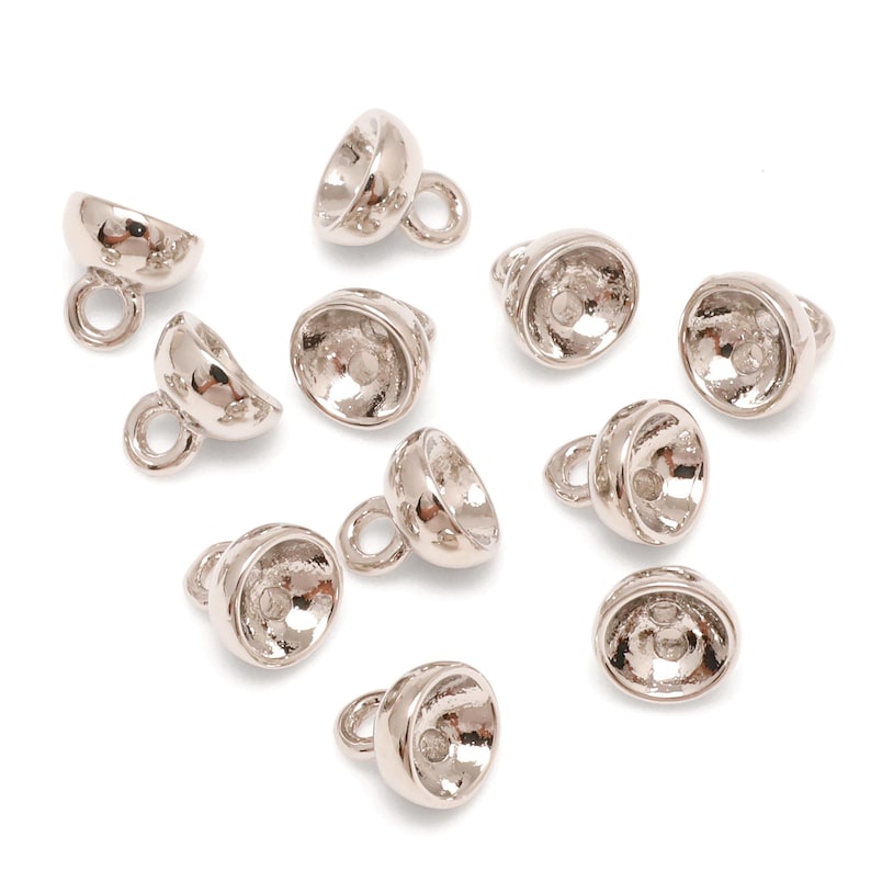 May include: A selection of silver-coloured metal bead caps, each with a rounded bell shape and a small loop for attaching to jewellery. These caps are designed to cover and finish the ends of beads or other components.