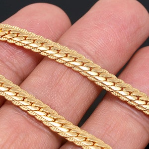 Puede incluir: Un collar de cadena de oro con un diseño trenzado texturizado.