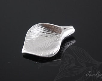 May include: A silver petal charm with a textured surface. The charm has a hole at the top for attaching to a necklace or bracelet.