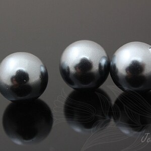 May include: Three round, smooth, gray pearl beads.