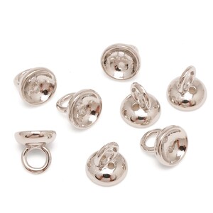 May include: A selection of silver-coloured metal jewellery findings, including ring bails and button-shaped components. The ring bails have a loop for attaching. The button-shaped pieces have a loop or hole for attaching.