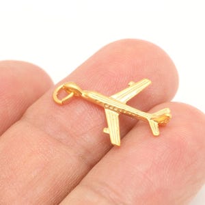 May include: Gold airplane charm pendant. The charm is detailed with a small loop for attaching to a necklace or bracelet.
