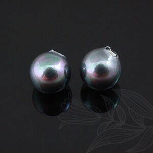 May include: Two black iridescent round pearls with a slight green hue.