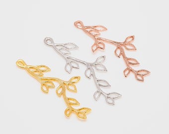 May include: Three metal branch charms in gold, silver, and rose gold. Each charm features a delicate, intricate design of leaves and branches.