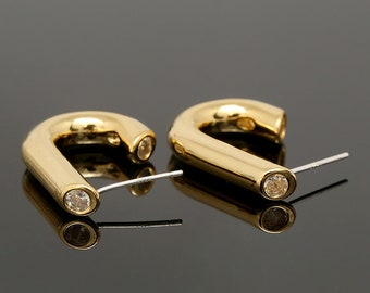 May include: A pair of gold hoop earrings with a clear crystal accent on each hoop.