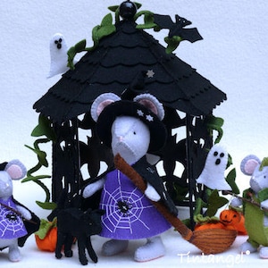 May include: A felt craft set featuring three mice dressed in Halloween costumes, including a witch with a purple spiderweb dress and broom, a small mouse with a pumpkin, and a dragon mouse, all positioned before a black felt gazebo with ghosts.
