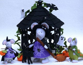 Könnte beinhalten: Ein Filz-Bastelset mit drei Mäusen in Halloween-Kostümen, darunter eine Hexe mit lila Spinnennetz-Kleid und Besen, eine kleine Maus mit Kürbis und eine Drachenmaus, die alle vor einem schwarzen Filz-Pavillon mit kleinen Geistern platziert sind.