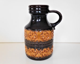 May include: A brown ceramic vase with a handle and a brown and orange floral pattern.