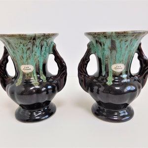 Peut inclure: Paire de vases en céramique brun et vert avec des anses. Chaque vase porte une étiquette indiquant "S&G Germany".